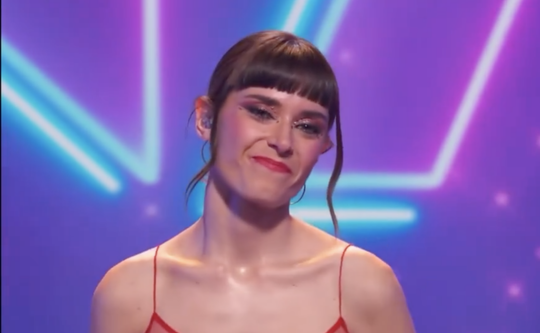 Aina Machuca smiling and holding a trophy on stage with confetti falling, celebrating her win on 'Eufòria'.