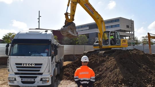 A modern apartment building with balconies and green spaces in a city setting, representing public housing.