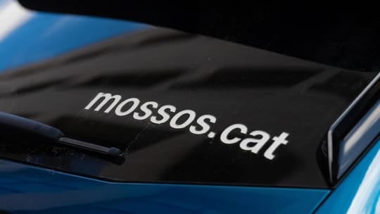 Mossos d'Esquadra police car with flashing blue lights parked on a street in Badalona