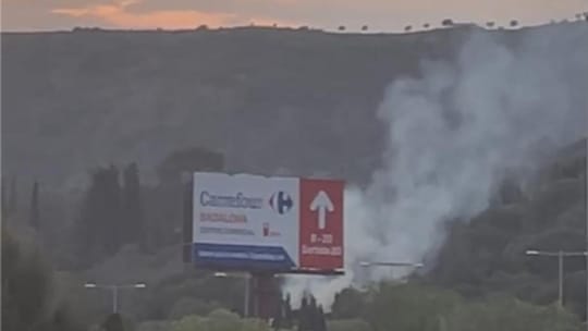 Smoke column rising from a mountainous area near the B-20 motorway exit in Badalona's Montigalà neighbourhood.