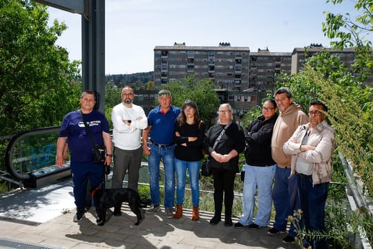 Residents gather in a town square with book and rose stalls, some dancing sardanas, in Badia del Vallès.