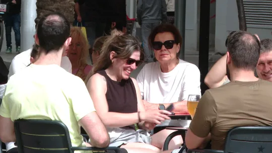 People enjoying full outdoor terraces on Rambla del Poblenou under warm April sunshine.