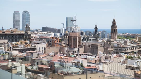 Apartment buildings on a residential Barcelona street, illustrating the city's rental market.