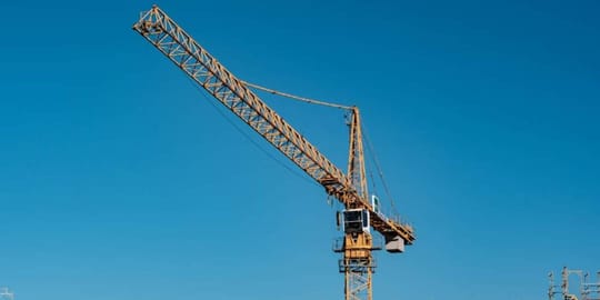 Emergency services personnel on a crane basket rescuing a man from a construction crane in Barcelona.