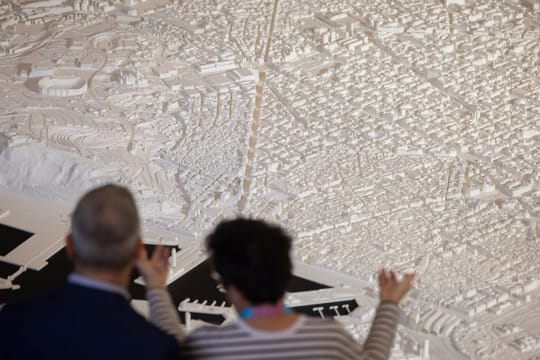 Architects gathered at a modern convention centre in Barcelona, discussing urban planning and sustainable design.