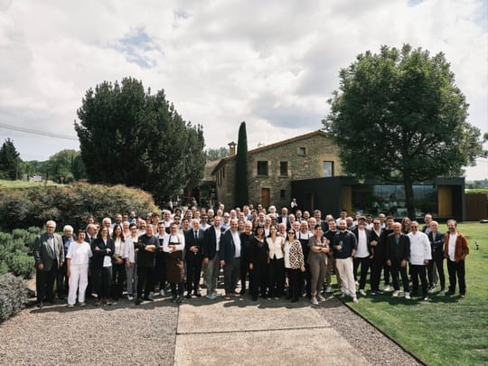 Ferran Adrià embracing a member of the Santamaria family at an event in Tona, surrounded by other chefs.