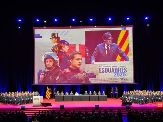 Generalitat President Salvador Illa speaking at the Dia de les Esquadres event with police officers in uniform.