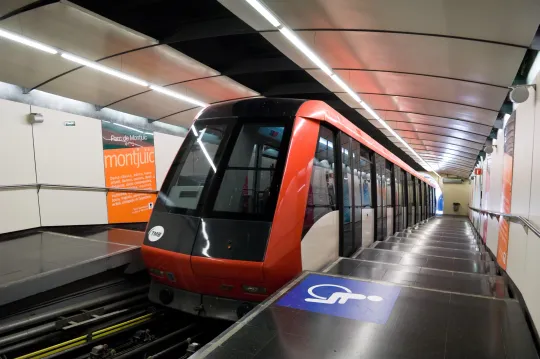 The Montjuïc Funicular train arriving at a station, with passengers waiting on the platform.