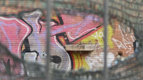 The Font de la Guineu, or Fox Fountain, in Barcelona's Navas neighbourhood, surrounded by trees and a low wall.