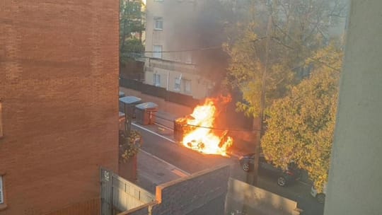 A street scene in Barcelona's Nou Barris district, showing residential buildings and a public square.