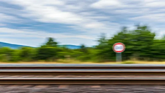 A train track with a speed limit sign, indicating temporary restrictions on the Rodalies network.