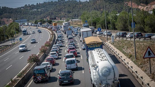Traffic diversion sign on a motorway with cars queuing due to a road closure