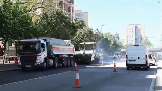 Construction vehicles and workers on Alfons XIII Avenue in Badalona, showing new asphalt being laid and widened pavements.