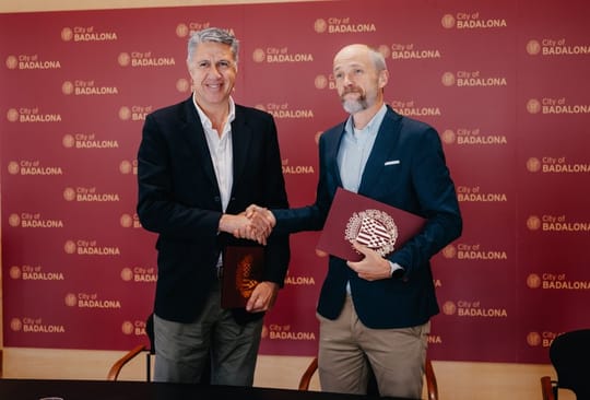 Badalona Mayor Xavier Garcia Albiol and Caprabo General Director Edorta Juaristi shaking hands after signing an agreement.