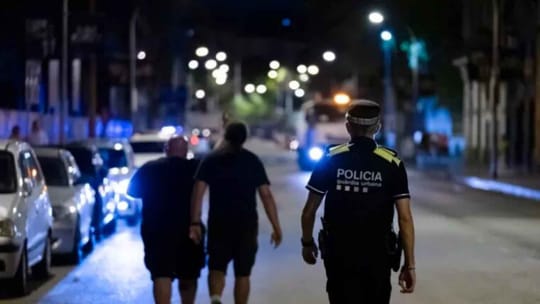 Police patrol in Badalona, a coastal city in the Barcelona metropolitan area, with residential buildings in the background.