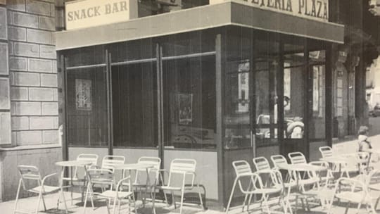 Exterior view of Bar La Plaza on Plaça Tetuán in Barcelona, showing its historic facade and a small terrace.