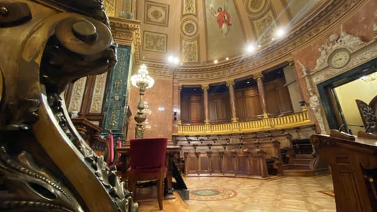 Barcelona Mayor Jaume Collboni speaks at a podium with the city's coat of arms visible.