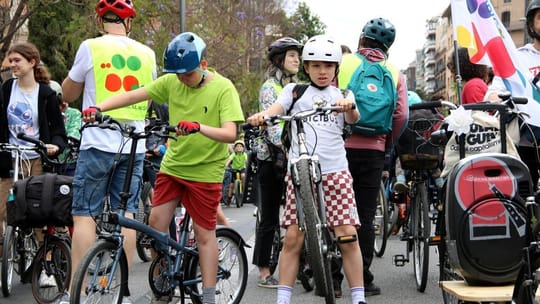 Families and children cycle through Barcelona streets during the Kidical Mass event.