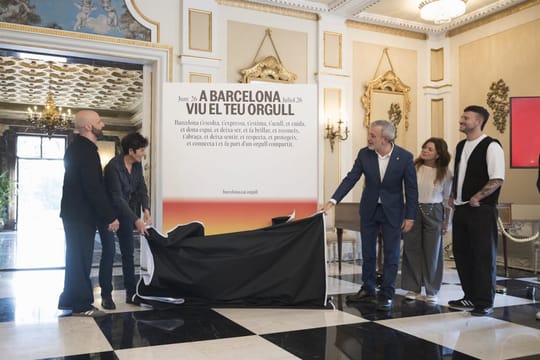Barcelona Mayor Jaume Collboni stands next to the 2026 Pride campaign poster, which features the slogan 'Live Your Pride'.