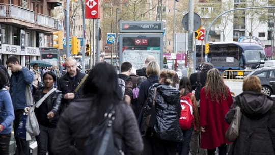 Crowded platform at Diagonal metro station in Barcelona with passengers waiting for a train.