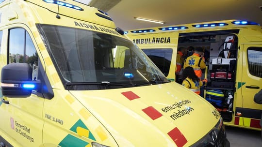 Emergency vehicles, including police cars and ambulances, at the scene of a road accident on a multi-lane highway at night.