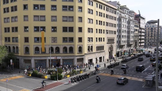 A wide, newly paved pedestrian street in Barcelona with trees and people walking, showing an example of urban pacification.