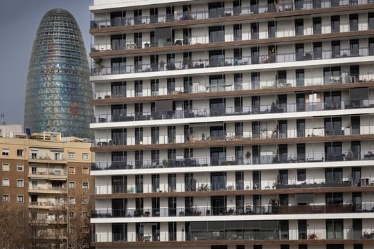 A residential building facade in Barcelona with balconies and clothes hanging, representing the city's housing.