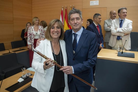 A group of local politicians, including a mayor, shaking hands at a public event in a Catalan town hall.