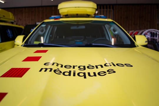Emergency services attend a road accident scene with a damaged motorcycle and cars.