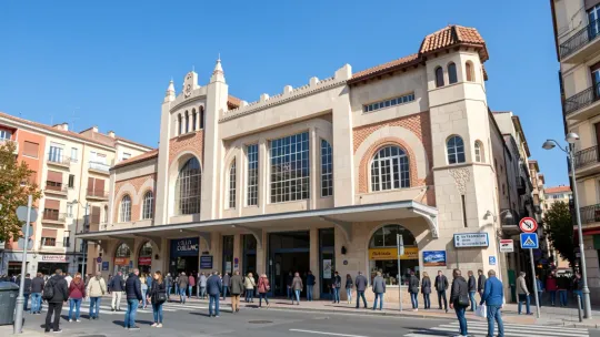 Exterior view of Mercat de Collblanc in L'Hospitalet de Llobregat, showing market stalls and shoppers.