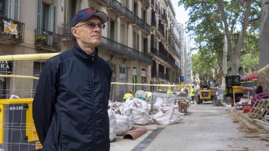 Construction workers and machinery on La Rambla in Barcelona, with temporary fencing and renovated sections visible.