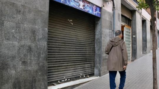 Police tape and officers investigating a street in L'Hospitalet de Llobregat after a shooting incident.