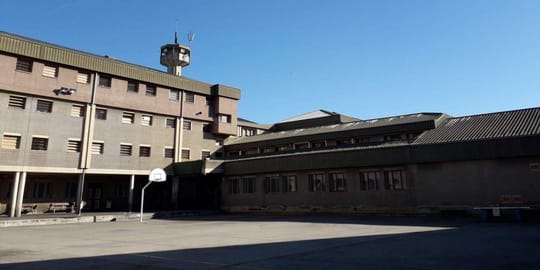 Exterior view of Quatre Camins prison in La Roca del Vallès, Catalonia, under a clear sky.