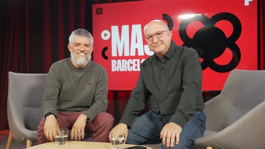 Oriol Jara, a man with short hair and glasses, smiling slightly while looking towards the camera, possibly in a studio settin