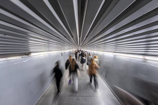 Busy metro corridor at Plaça Catalunya station in Barcelona with many passengers walking.