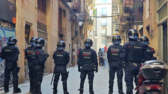 Protesters holding signs outside a building in Barcelona's El Raval district, demonstrating against an eviction.