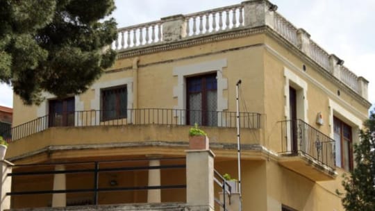 Historic Can Collblanch estate building with a garden in Santa Coloma de Gramenet, Barcelona.