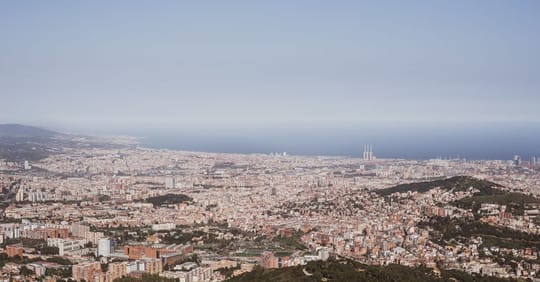 Aerial view of Barcelona's coastline, showing beaches, promenades, and urban areas stretching from Barceloneta towards Sant A