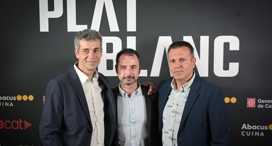 Three chefs, Oriol Castro, Eduard Xatruch, and Mateu Casañas, standing proudly in a professional kitchen, possibly at Disfrut