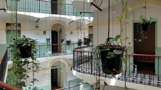 Interior courtyard of Hotel Peninsular in Barcelona's Raval, featuring balconies and a fountain.
