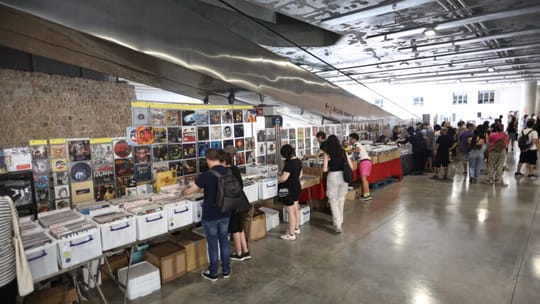 People browsing vinyl records at stalls inside the Fossat area of Sant Antoni Market in Barcelona