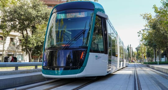 Trambesòs tram travelling along a street in Barcelona with buildings in the background