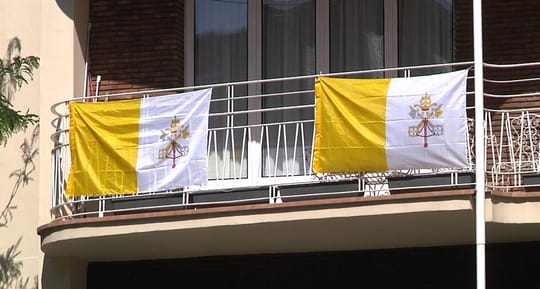 Vatican flags hang from balconies in Barcelona's Sarrià-Sant Gervasi district.