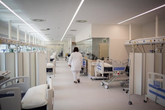 Doctor using a tablet to complete a digital form in a hospital setting.