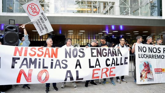 Nissan workers protest in Barcelona city centre, holding banners and flags.