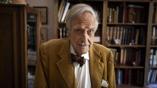 Oriol Domènec Llavallol, a 102-year-old man, sitting in his Barcelona home surrounded by photos and books.