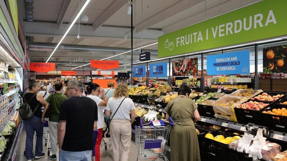Aldi supermarket exterior with red and white logo, shopping trolleys, and customers entering the store.