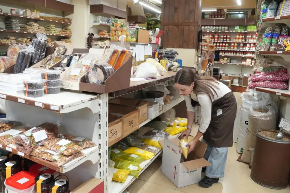 A person working on a laptop in a cafe, representing a self-employed individual.