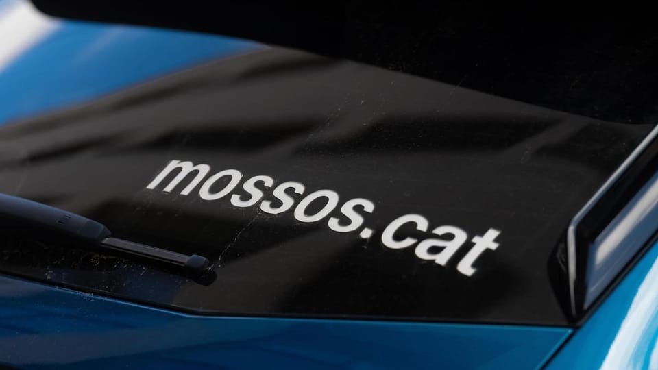 Mossos d'Esquadra police car with flashing blue lights parked on a street in Badalona