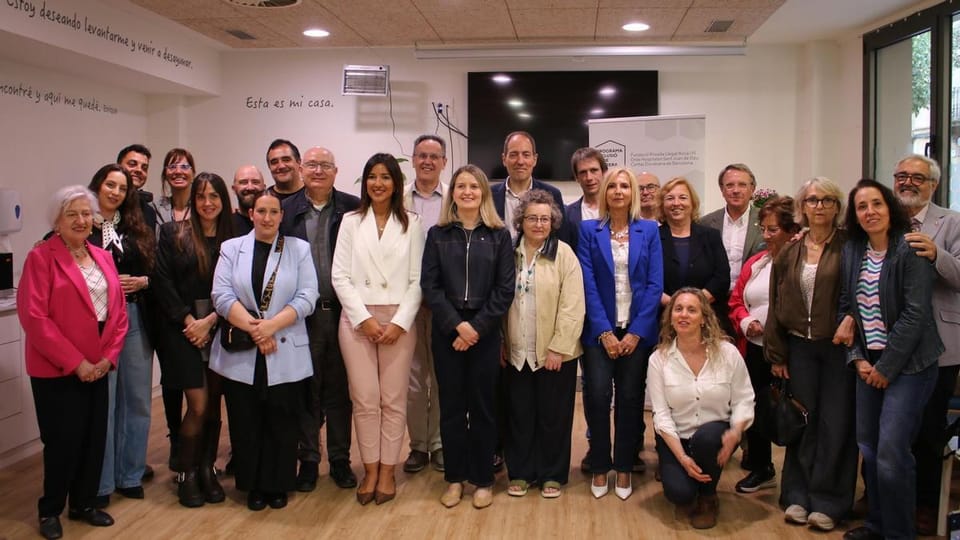 People gathered inside a community centre, possibly the Folre day centre, with officials speaking at a podium.